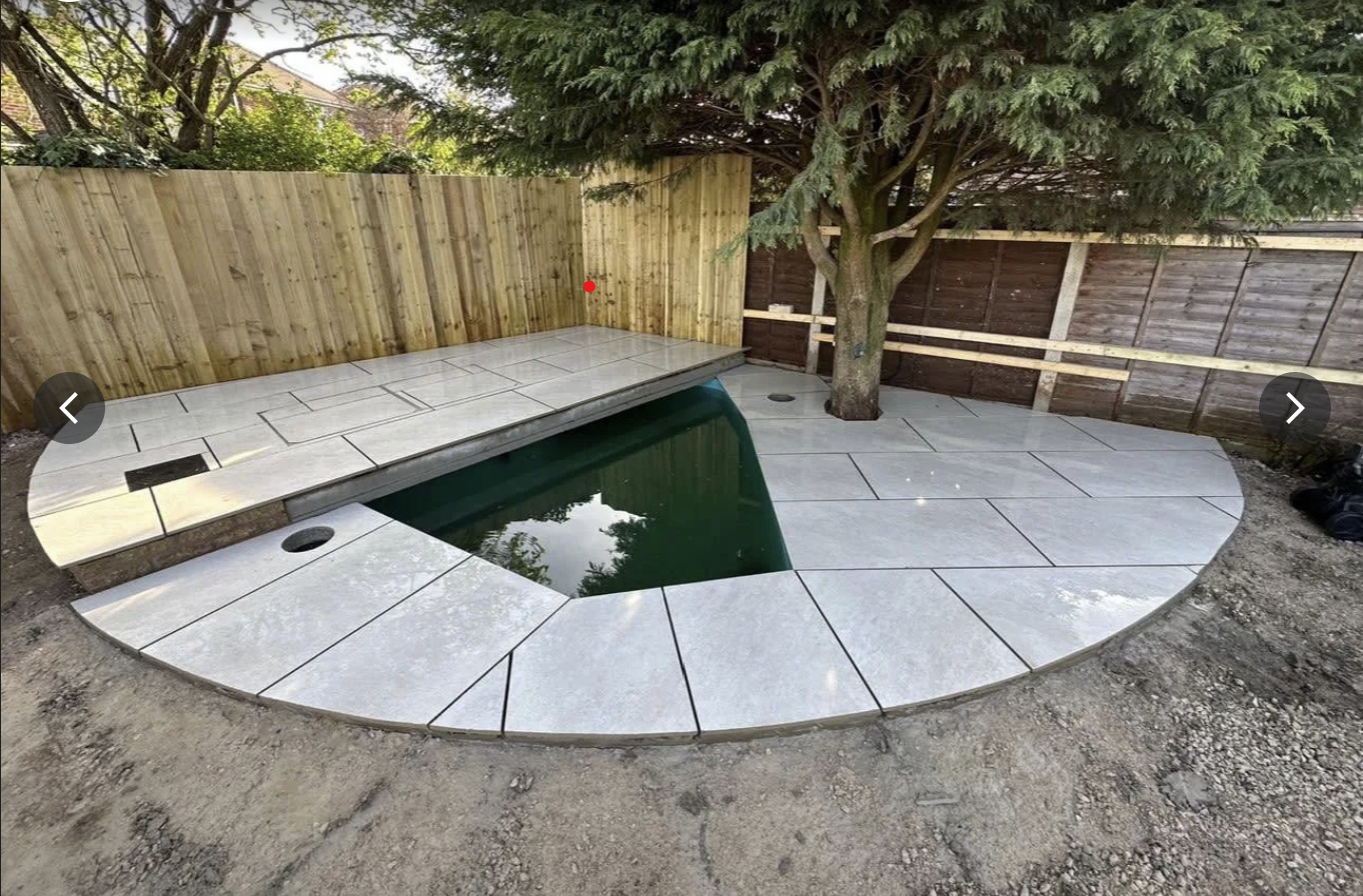 Curved porcelain patio installation in a landscaped garden
